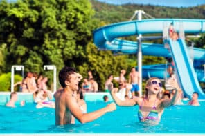 Un couple s'amuse dans la piscine d'un camping avec parc aquatique en Ardèche.