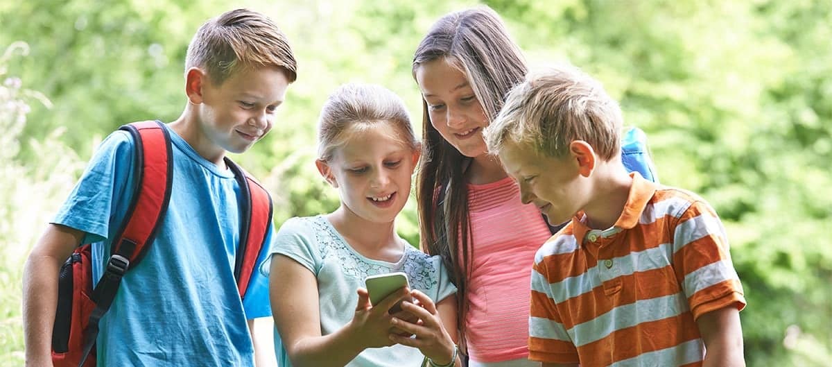 Des enfants jouent avec une application de geocaching