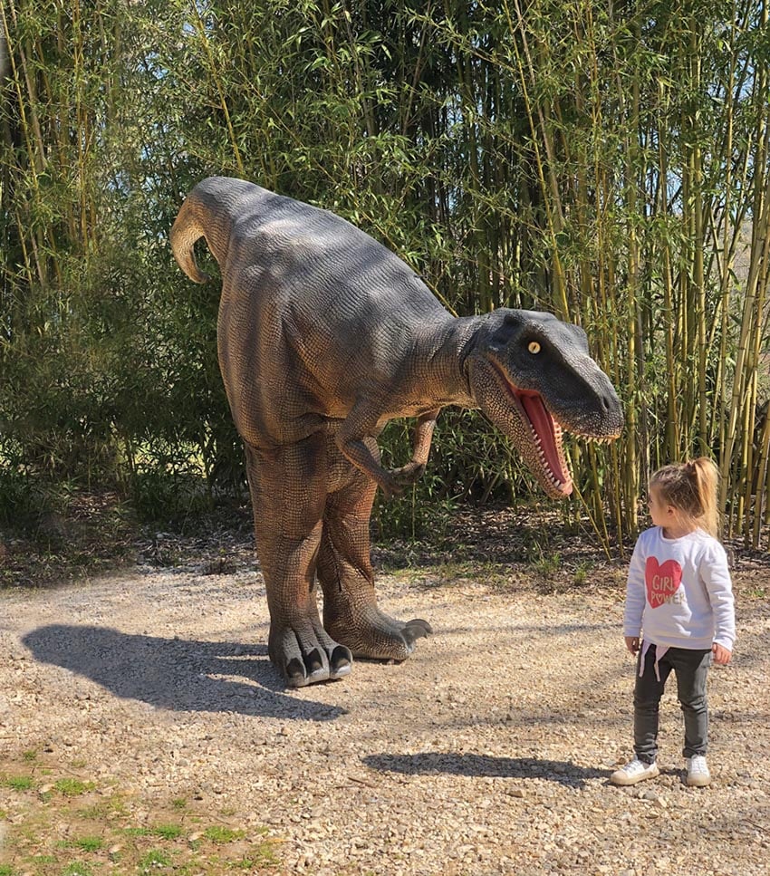 Petite fille au parc aux dinosaures